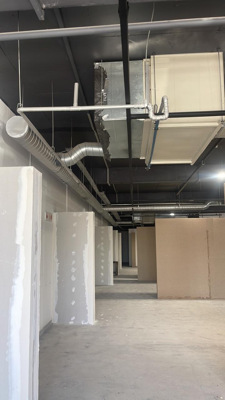 Ducting and air conditioning units above an office corridor during fit-out.