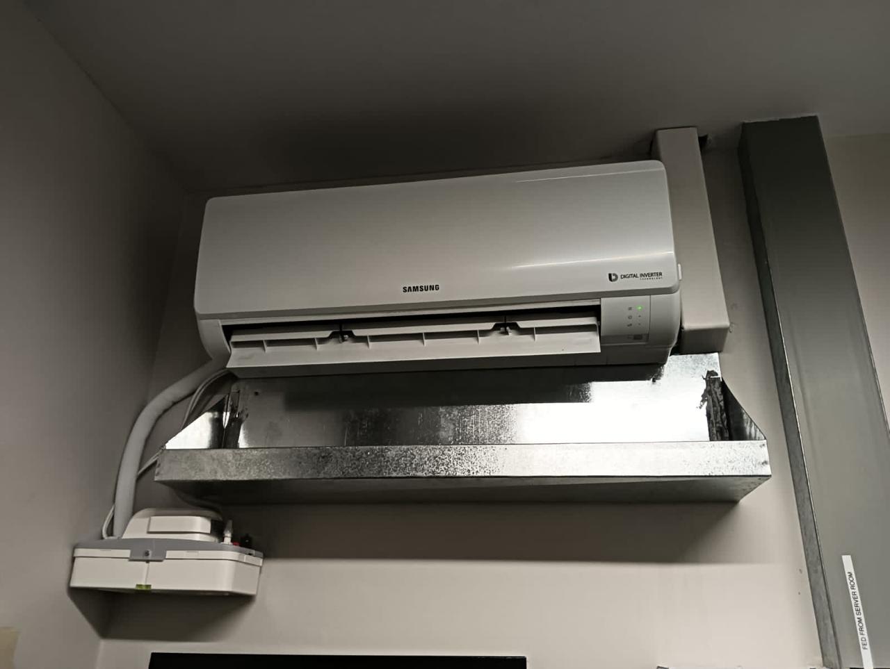 Wall-mounted split unit serviced, with a drip tray for condensate.