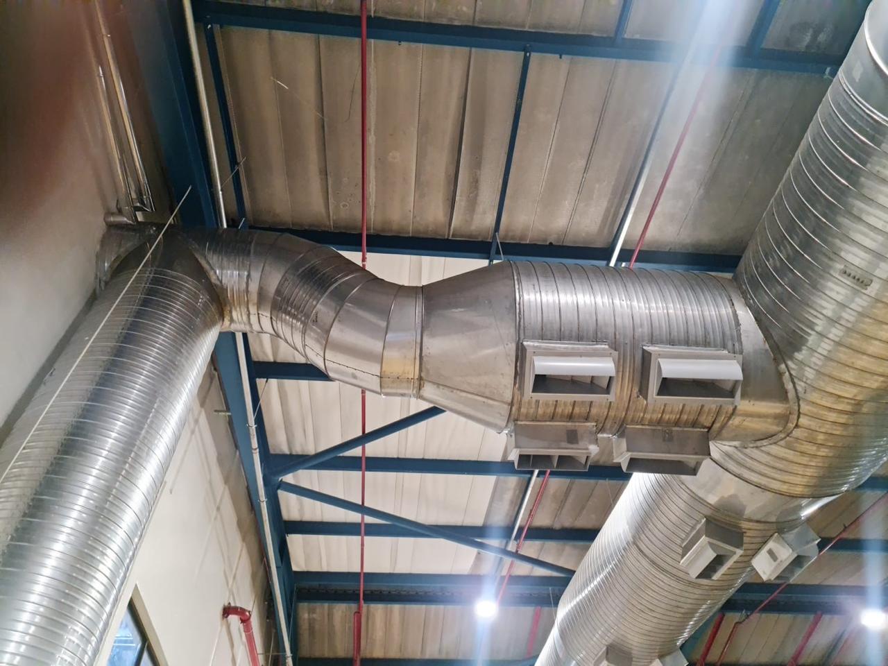 Spiral ducting with side outlets in a warehouse.