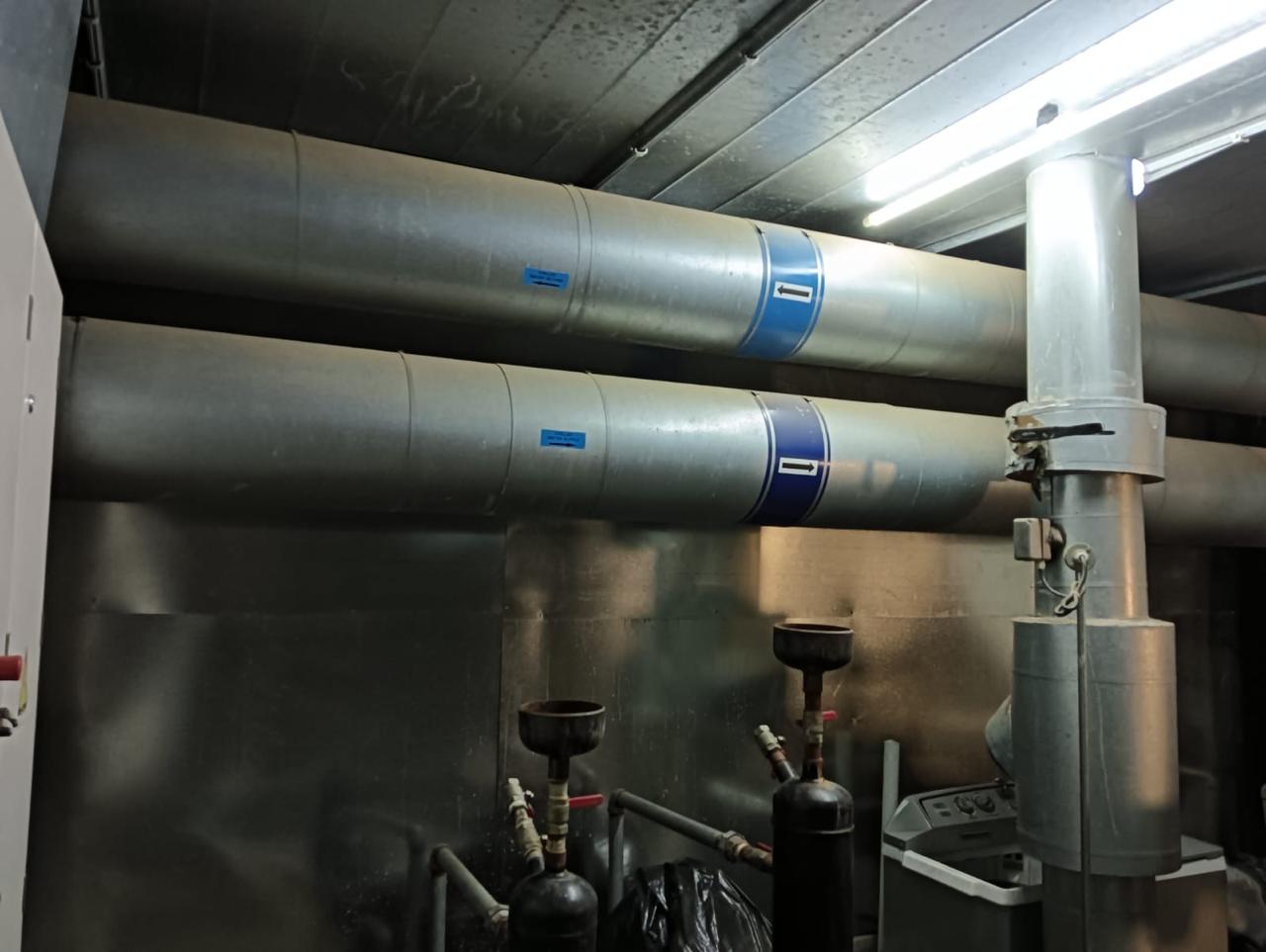 Equipment-room pipework and water-treatment dosing pots.