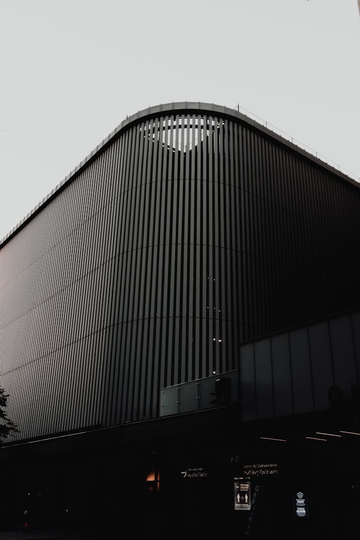 A sleek modern building exterior with vertical lines, showcasing futuristic architecture in an urban setting.