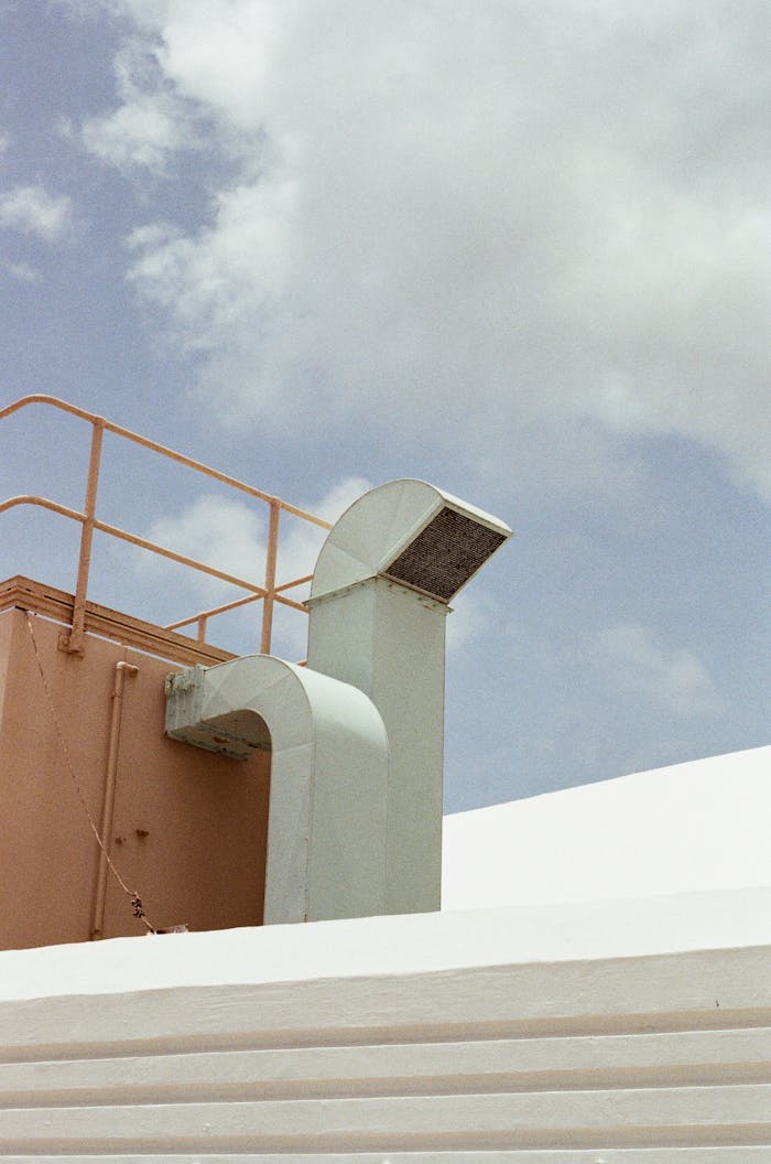 Roof ventilation system with a background of blue and cloudy sky.