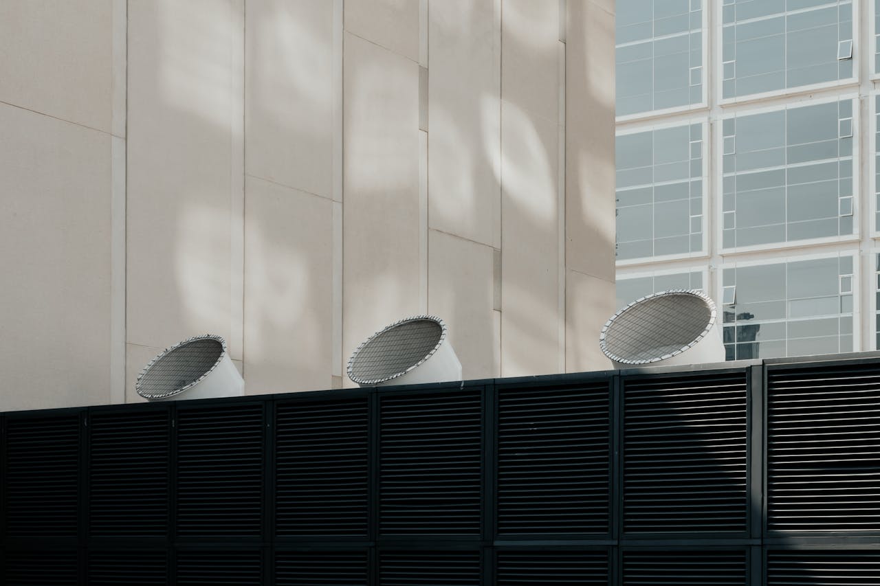 Contemporary building design featuring ventilation systems against a city backdrop.